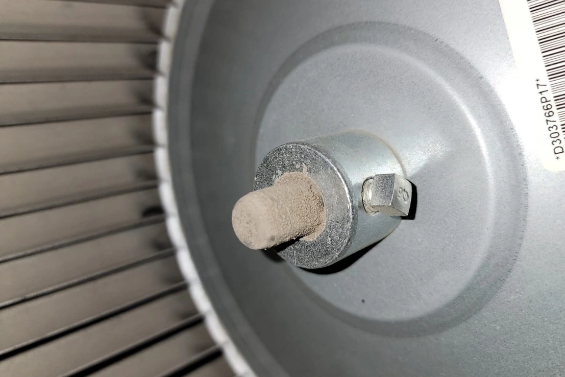 Dusty blower wheel and motor shaft inside a furnace during furnace maintenance in Bellevue, WA.