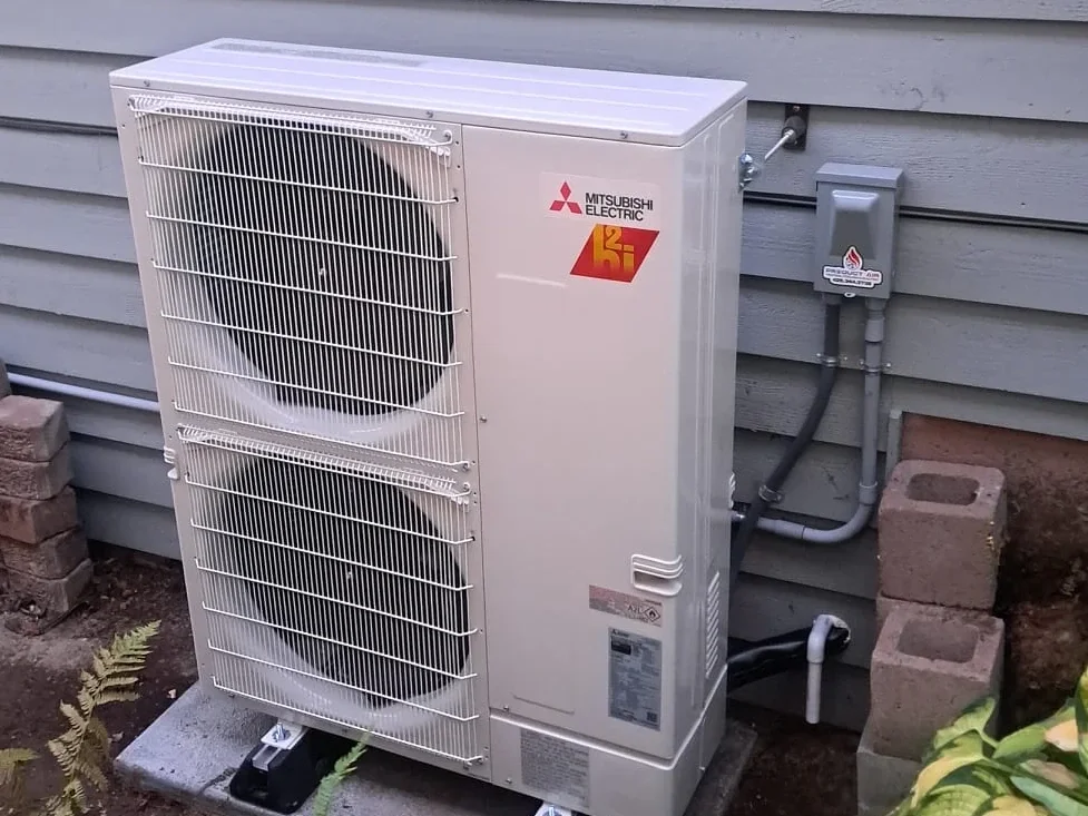 Mitsubishi Hyper Heat outdoor heat pump installed on a pad beside a home in Everett, WA.