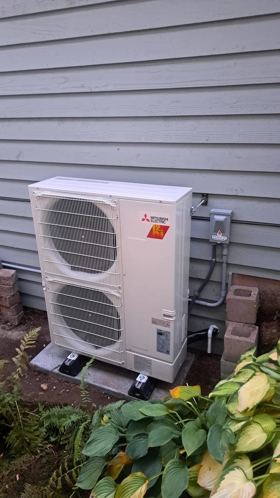 Mitsubishi outdoor heat pump installed beside the Everett home