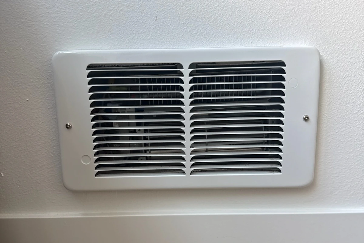 White electric wall heater with louvered grille installed in a home in Kirkland, WA.