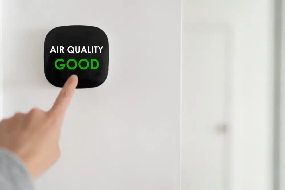 An air quality system on the wall displaying a positive air quality status, with helpful tips for improving indoor air conditions.